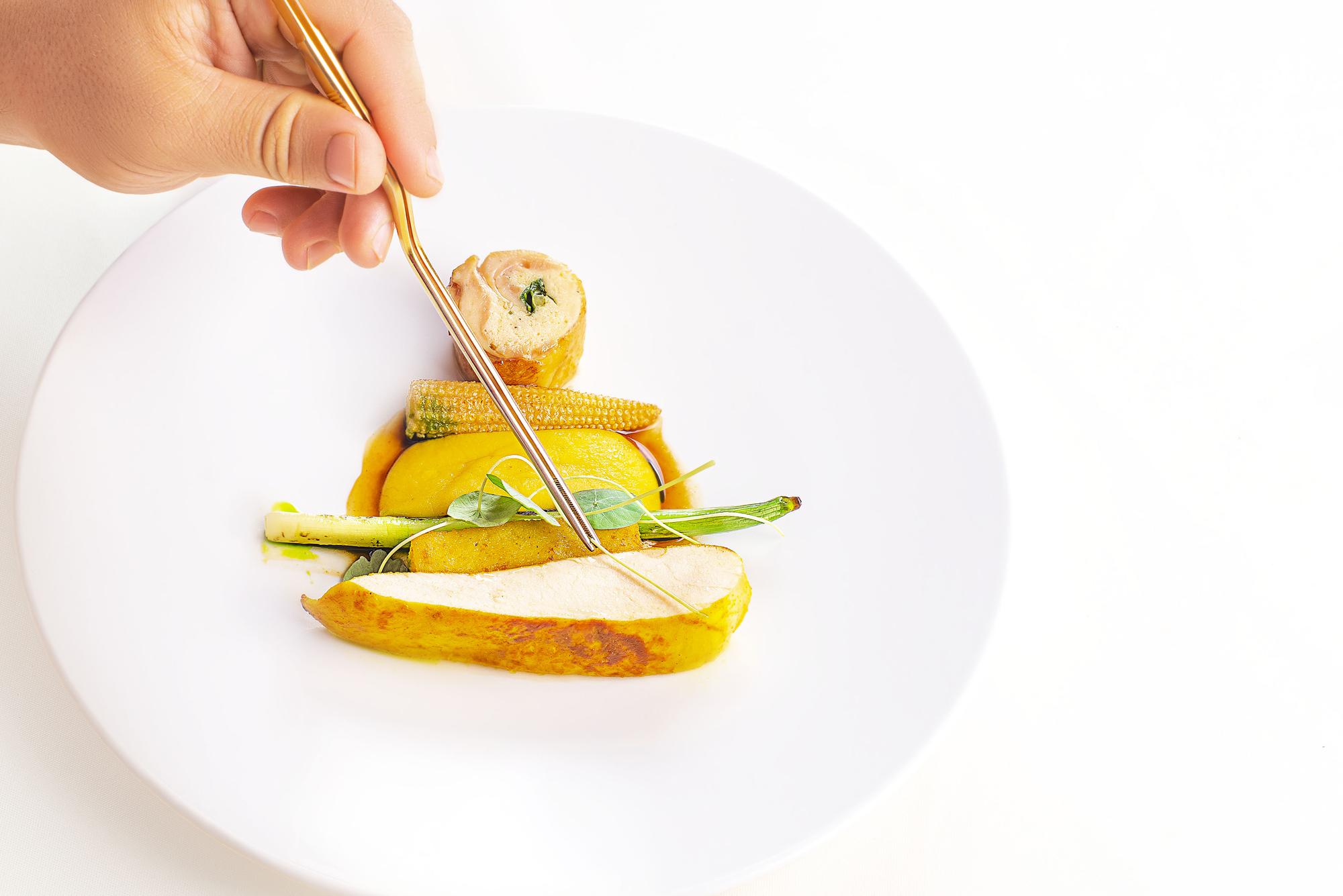 Chef preparing a colorful dish on a bright table